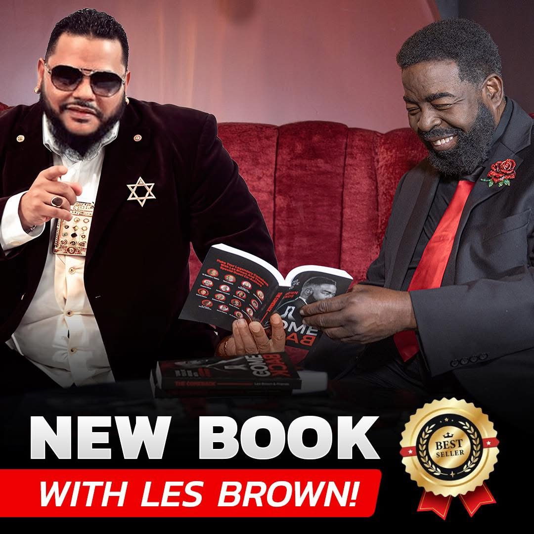 Two men sitting on a red couch, one holding a book, both smiling, with a black background and text about a new book.