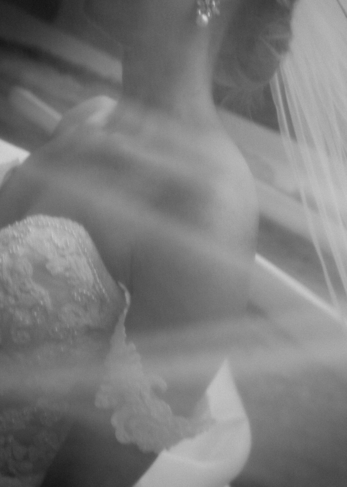 Back of a person with a towel wrapped around their waist, standing near a window with blinds.