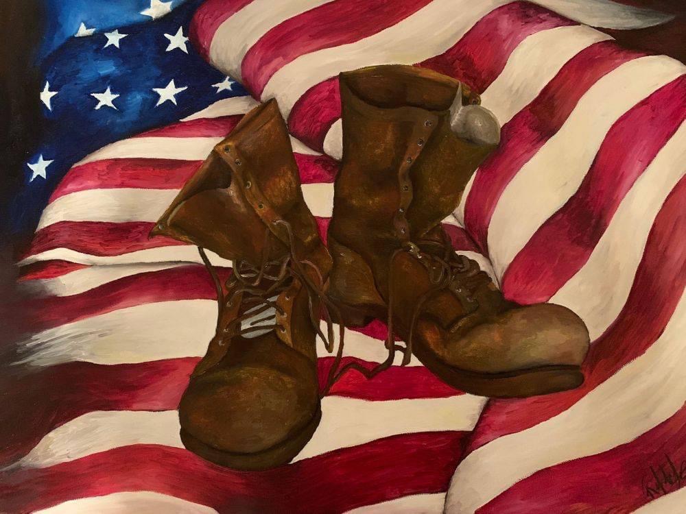 Pair of brown combat boots on an American flag with stars and stripes.