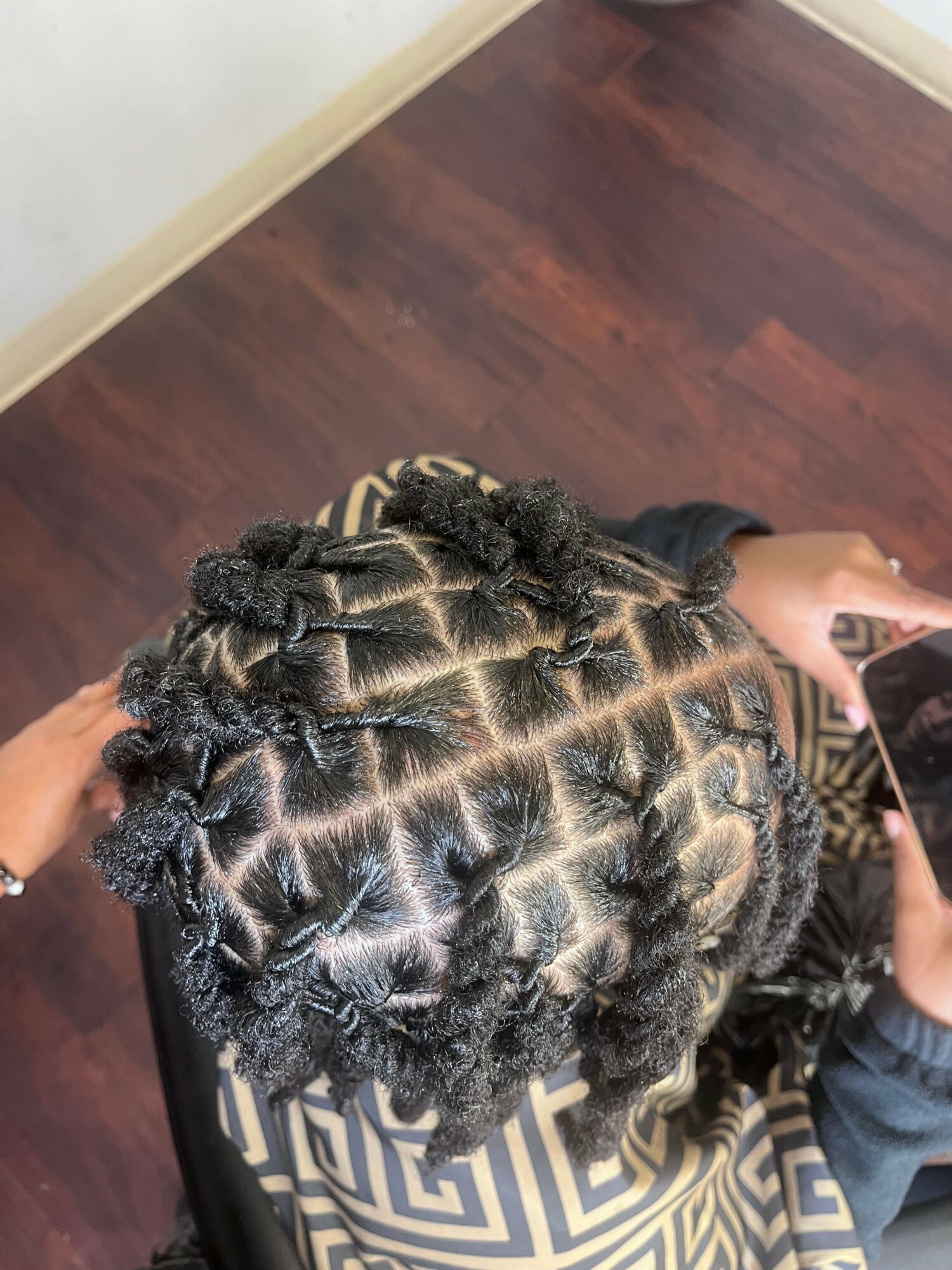 Top view of a person's head with styled, twisted hair arranged in neat sections.