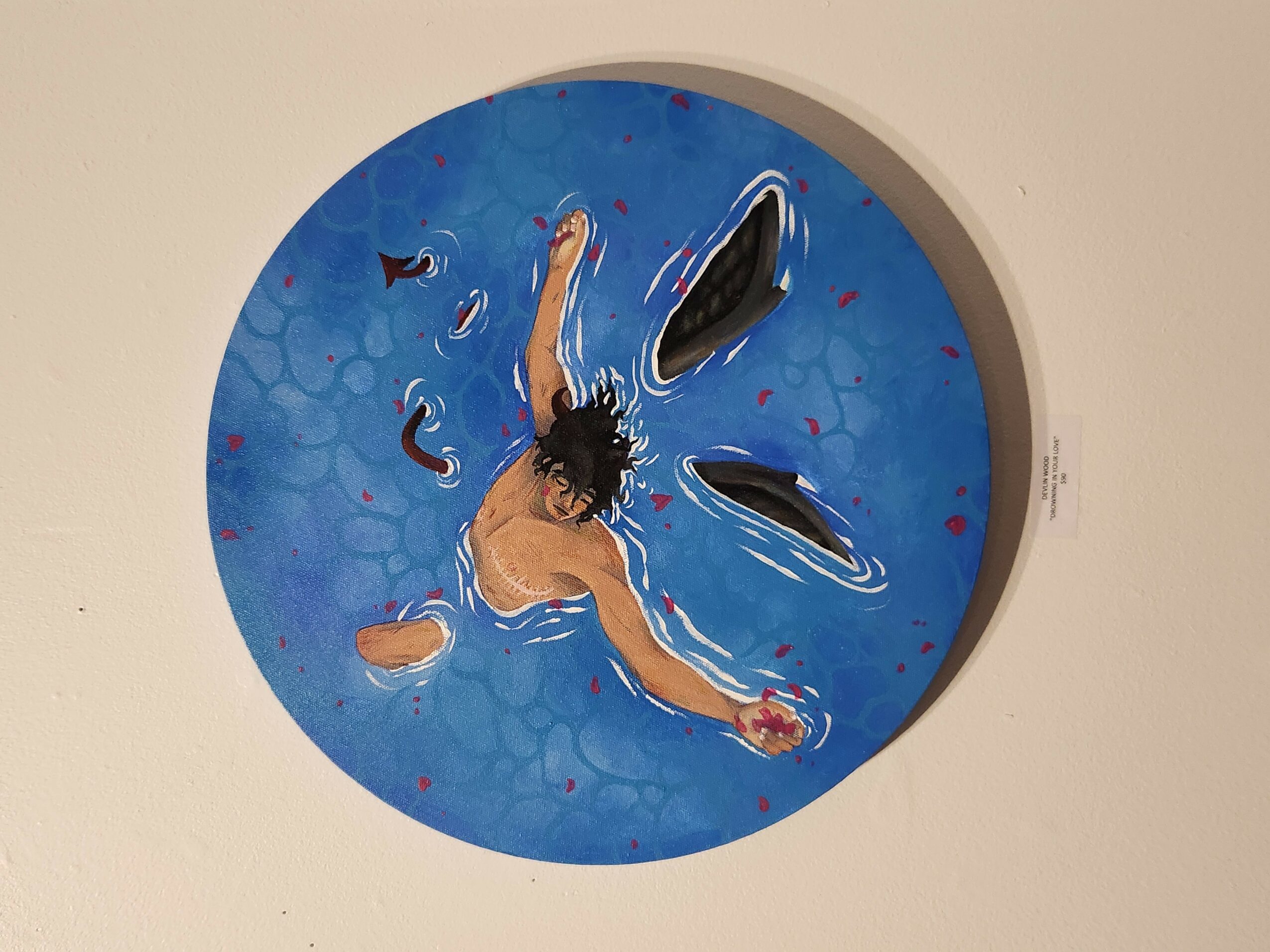 Person swimming in a circular pool with blue water, surrounded by a white border, viewed from above.