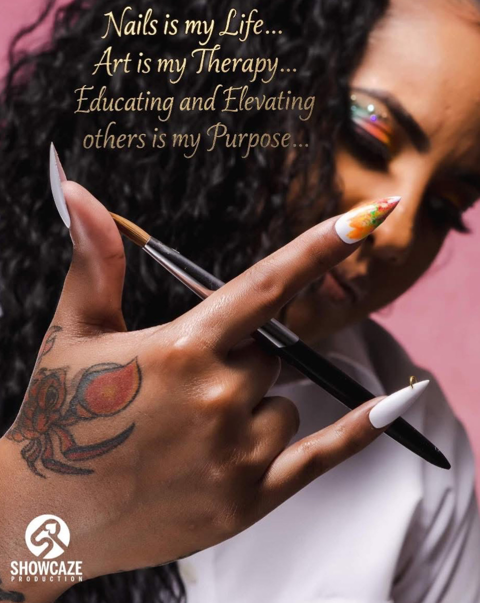 Close-up of a woman's hand with colorful nail art, holding a nail brush, with a tattoo on her wrist, and text overlay.