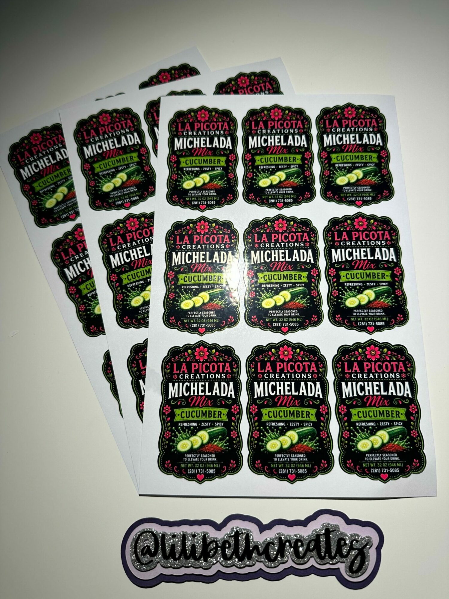 Sheet of stickers with black background, green and pink text, and images of berries, with a purple and white logo on the right.