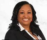 A woman with black hair, smiling, wearing a black blazer and white shirt, against a white background.