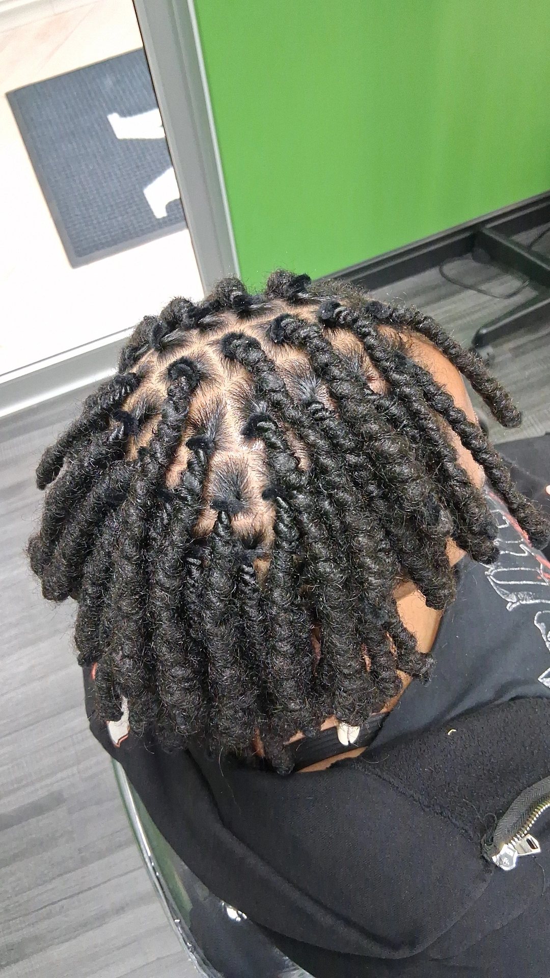 Top view of a person's head with styled dreadlocks, showing the hair's texture and pattern.