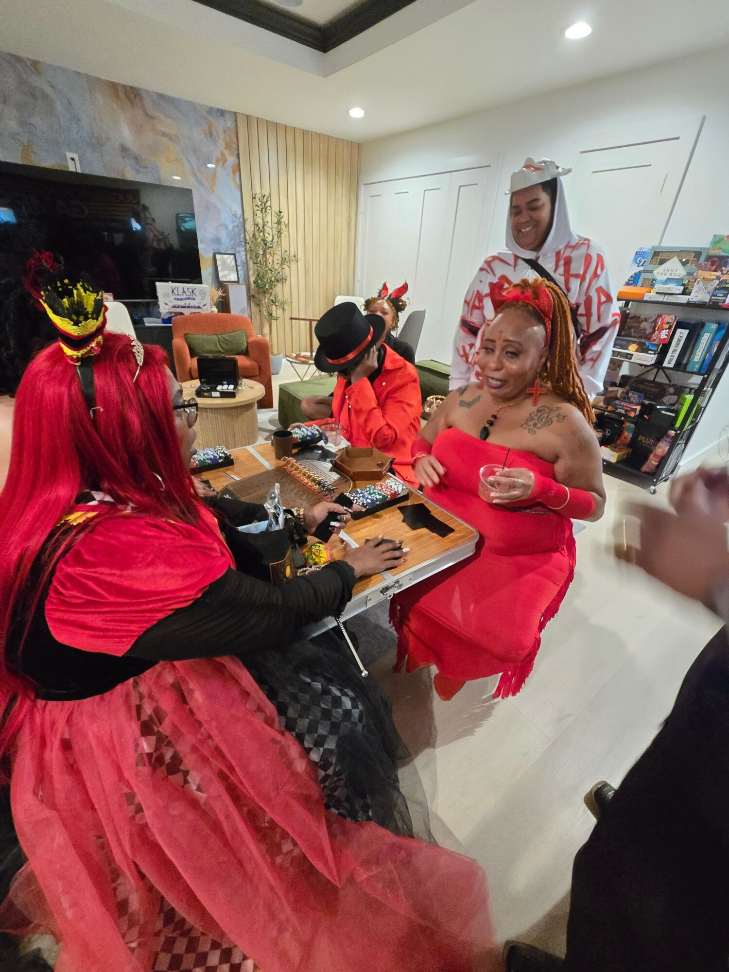 People in costumes gather around a table in a room with bright lighting and modern decor.