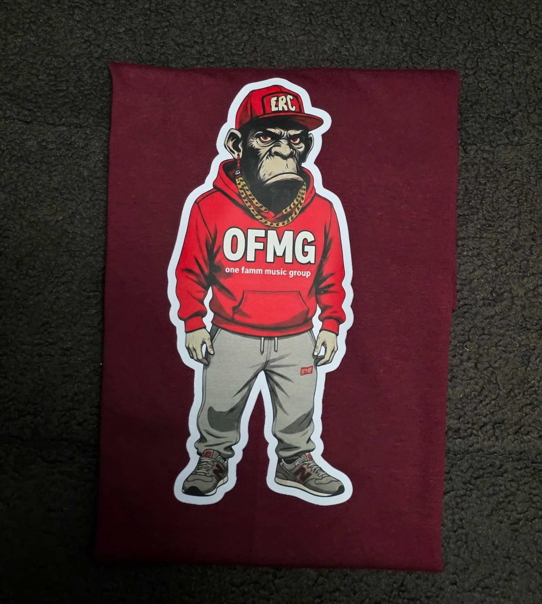 Sticker of a person with dreadlocks wearing a red hoodie and gray pants, standing with hands in pockets, on a maroon background.