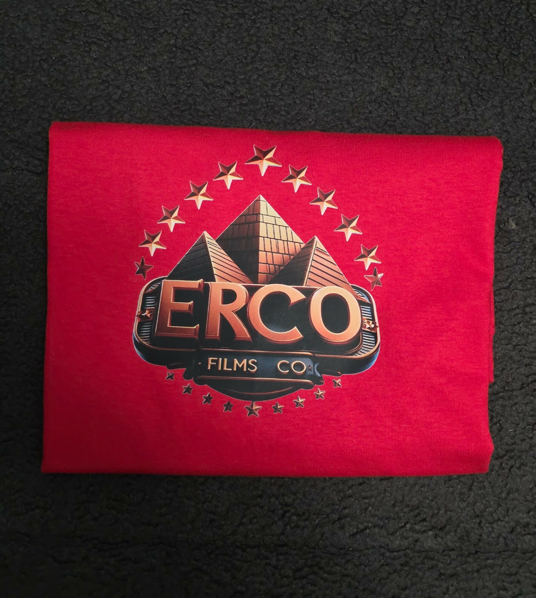 Red fabric with a vintage-style logo featuring a camera, stars, and the word 'CERC' in bold letters.