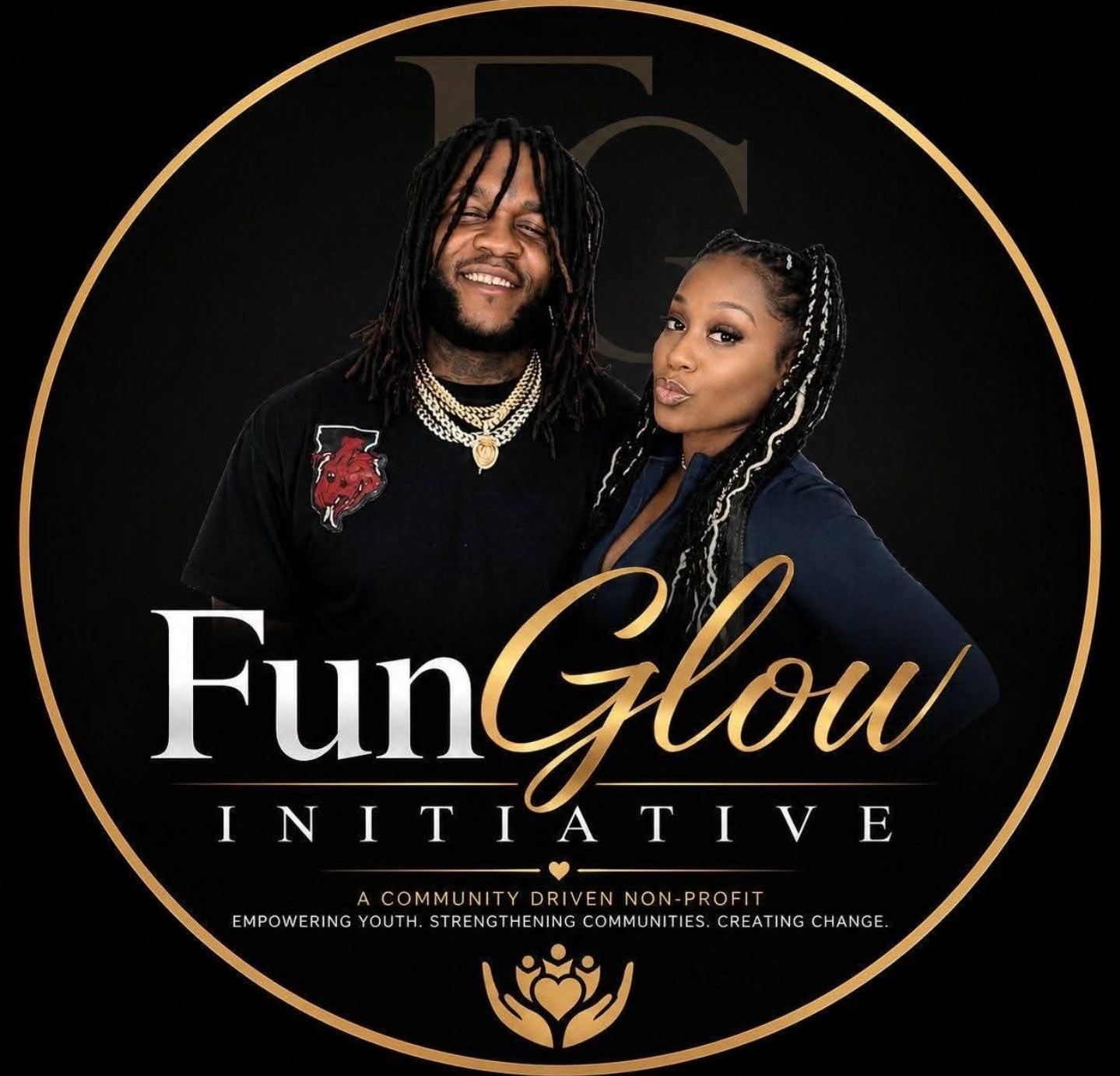 Two smiling people pose together, one with dreadlocks and the other with braided hair, in front of a black background with gold accents.