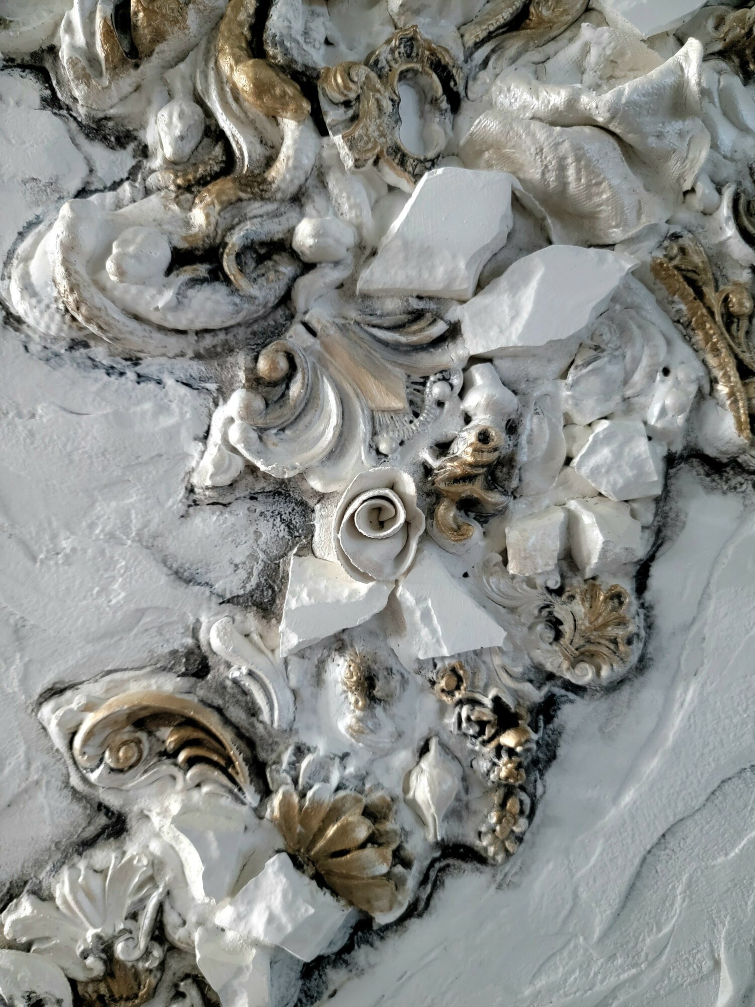 Close-up of seashells and coral fragments on a sandy surface, with some shells partially buried.