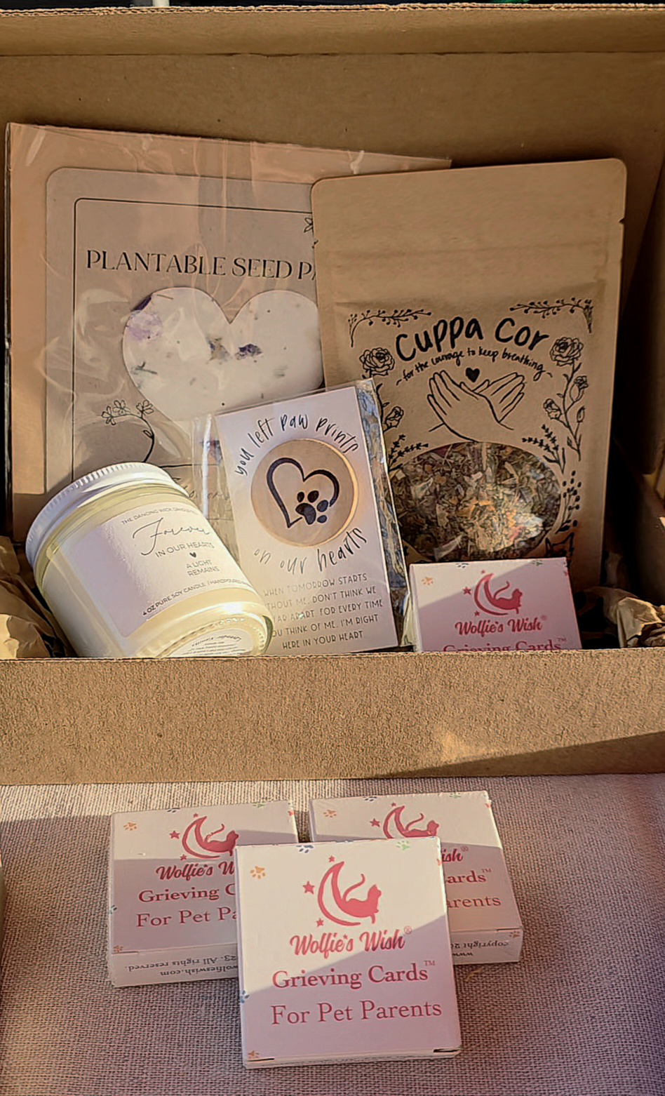 Open box containing pet care items, cards, and packaging materials, with some items stacked and partially visible.