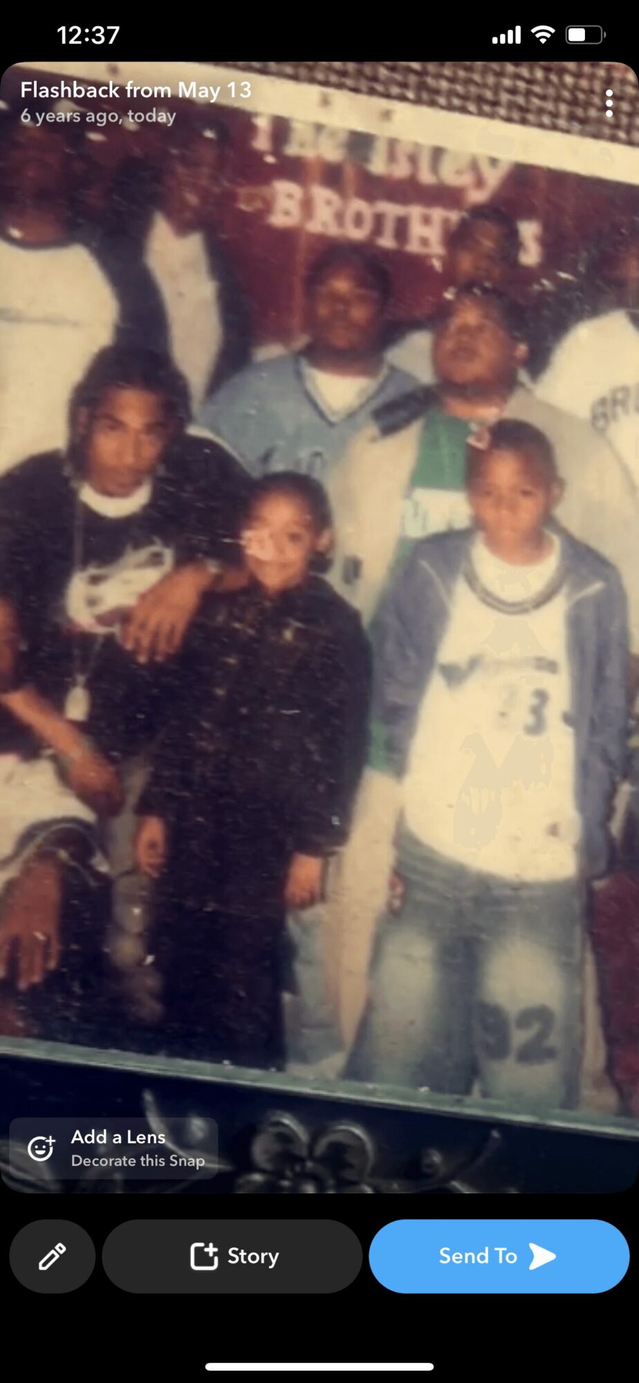 Group of six children standing together, some wearing sports jerseys, in a casual setting.