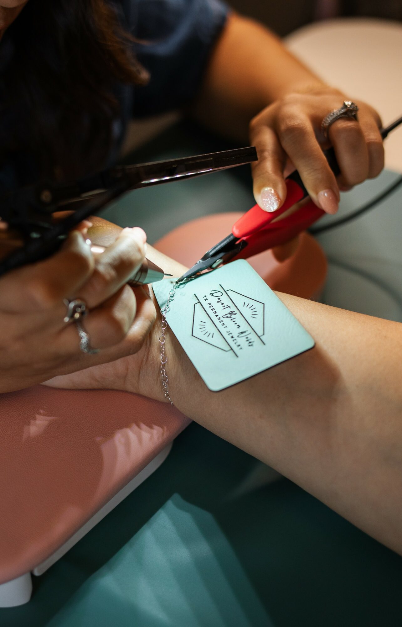 Person drawing on a small whiteboard attached to a person's arm with a red marker, in a clinical setting.