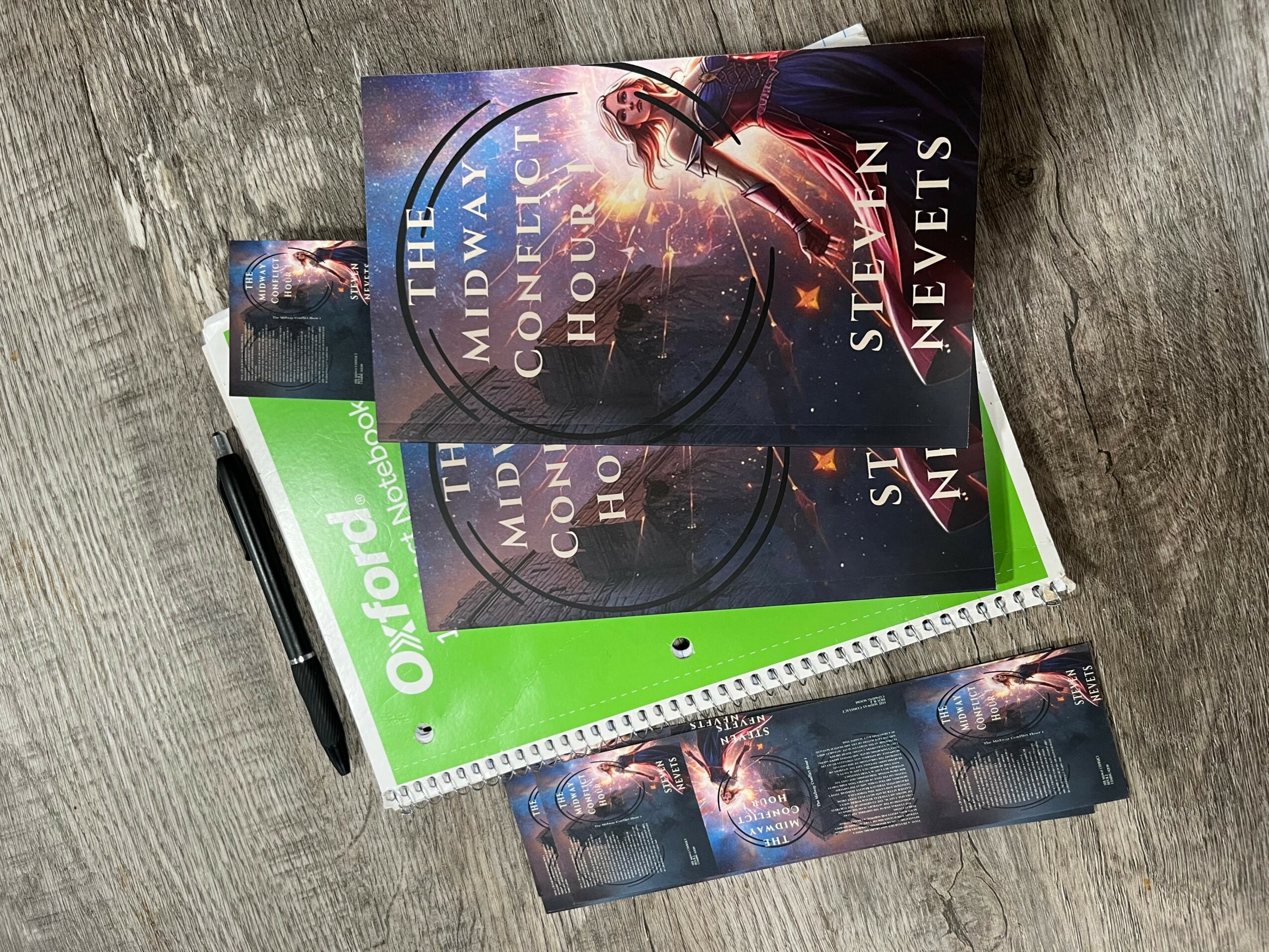 Books and a notebook on a wooden surface, with a book titled 'Midnight Council of the House' on top.