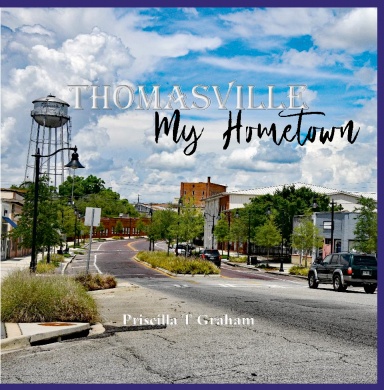 Street view with trees, buildings, and cars under a partly cloudy sky, with text overlay about Thomasville and hometown.