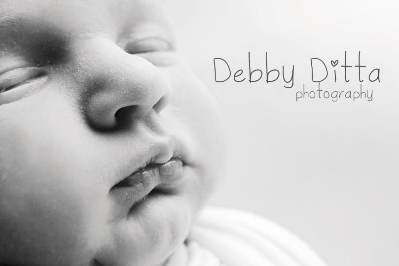 Close-up of a sleeping baby's face with closed eyes and relaxed lips, in black and white.