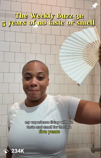 Person with a shaved head smiling in front of tiled wall, holding a fan, with yellow text about taste and smell, 20 words.