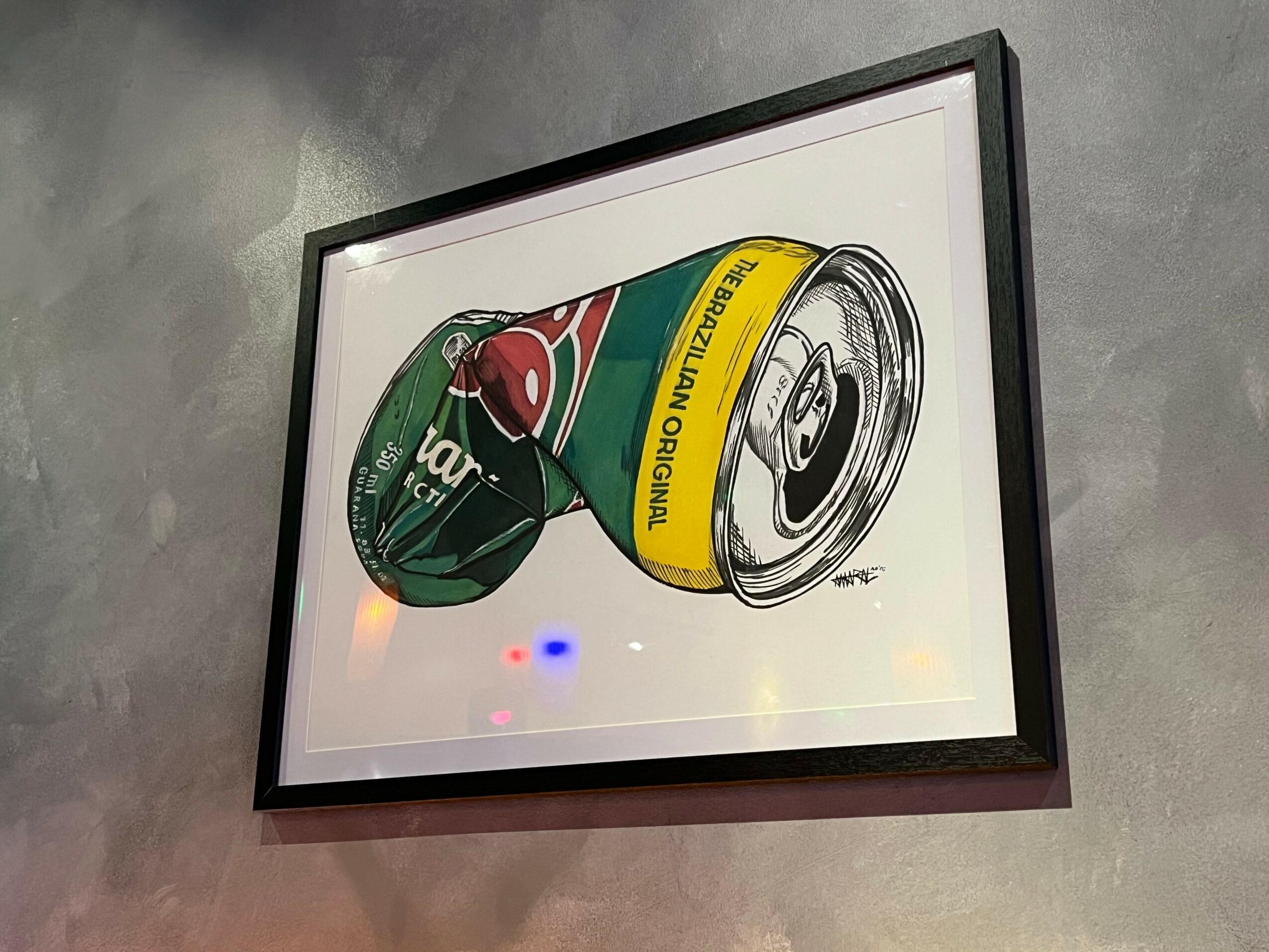 Framed artwork of a crushed soda can and a bottle cap on a white background.
