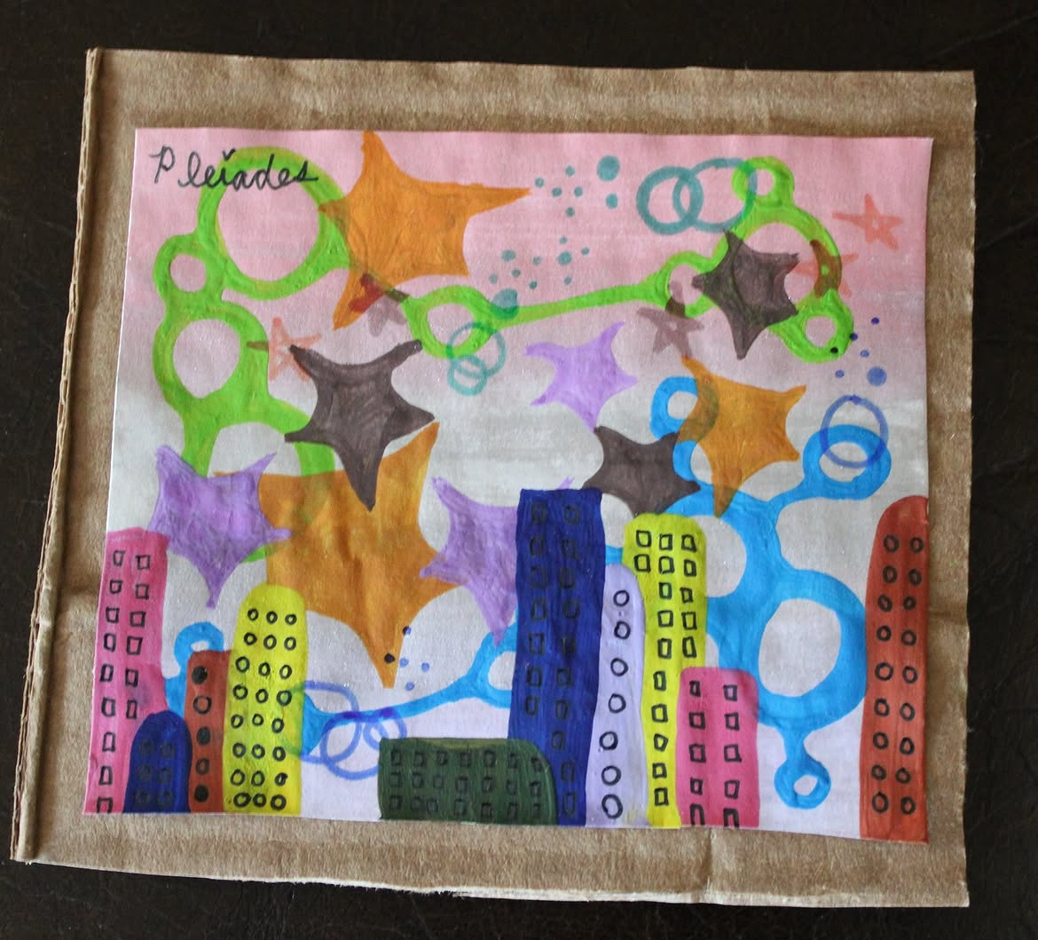 Colorful drawing of stars, circles, and buildings with a cityscape background, on pink paper with a brown border.