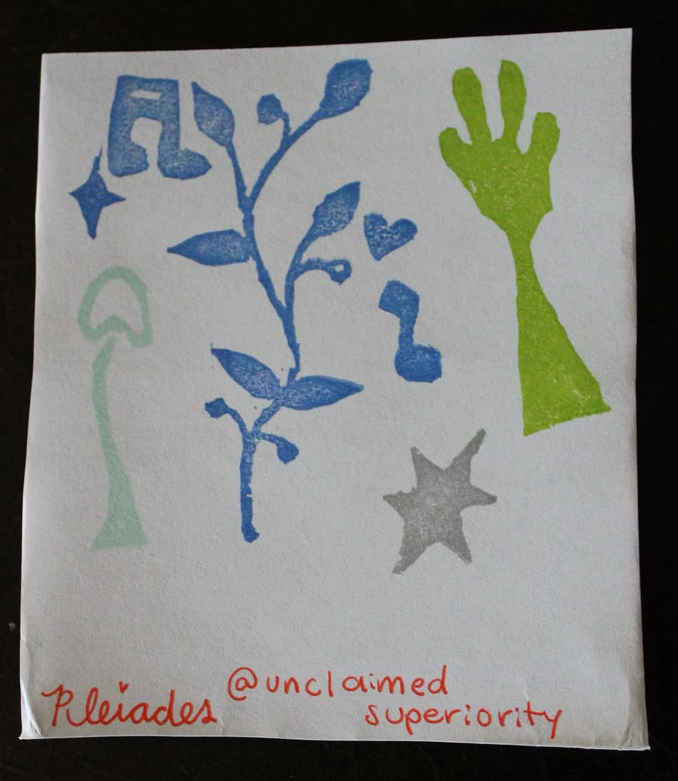 Colorful handprint, star, plant, and abstract shapes on paper, with handwritten text in red and blue ink.