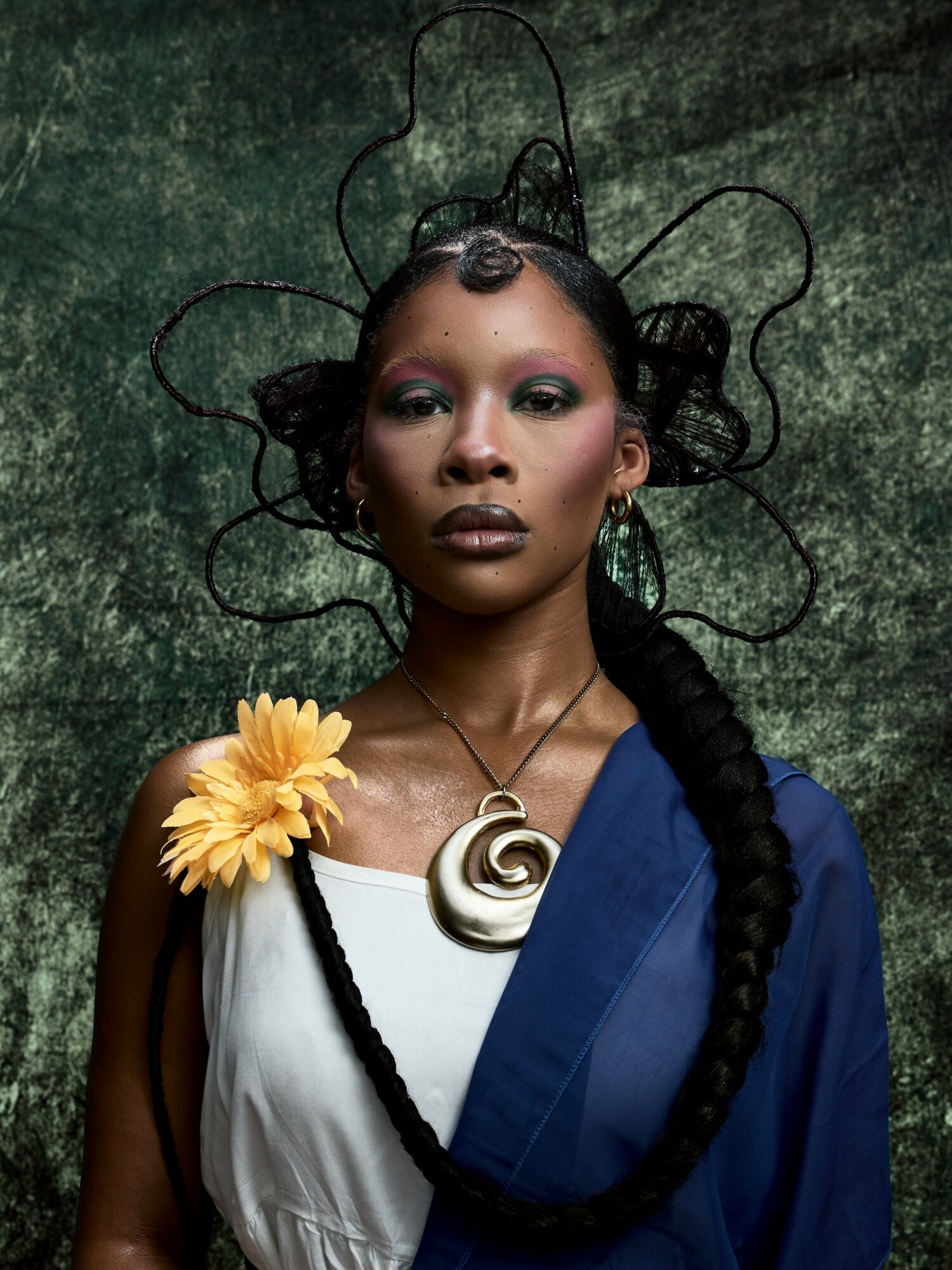 Portrait of a woman with elaborate hair accessories, wearing a white and blue outfit, and a large spiral necklace.