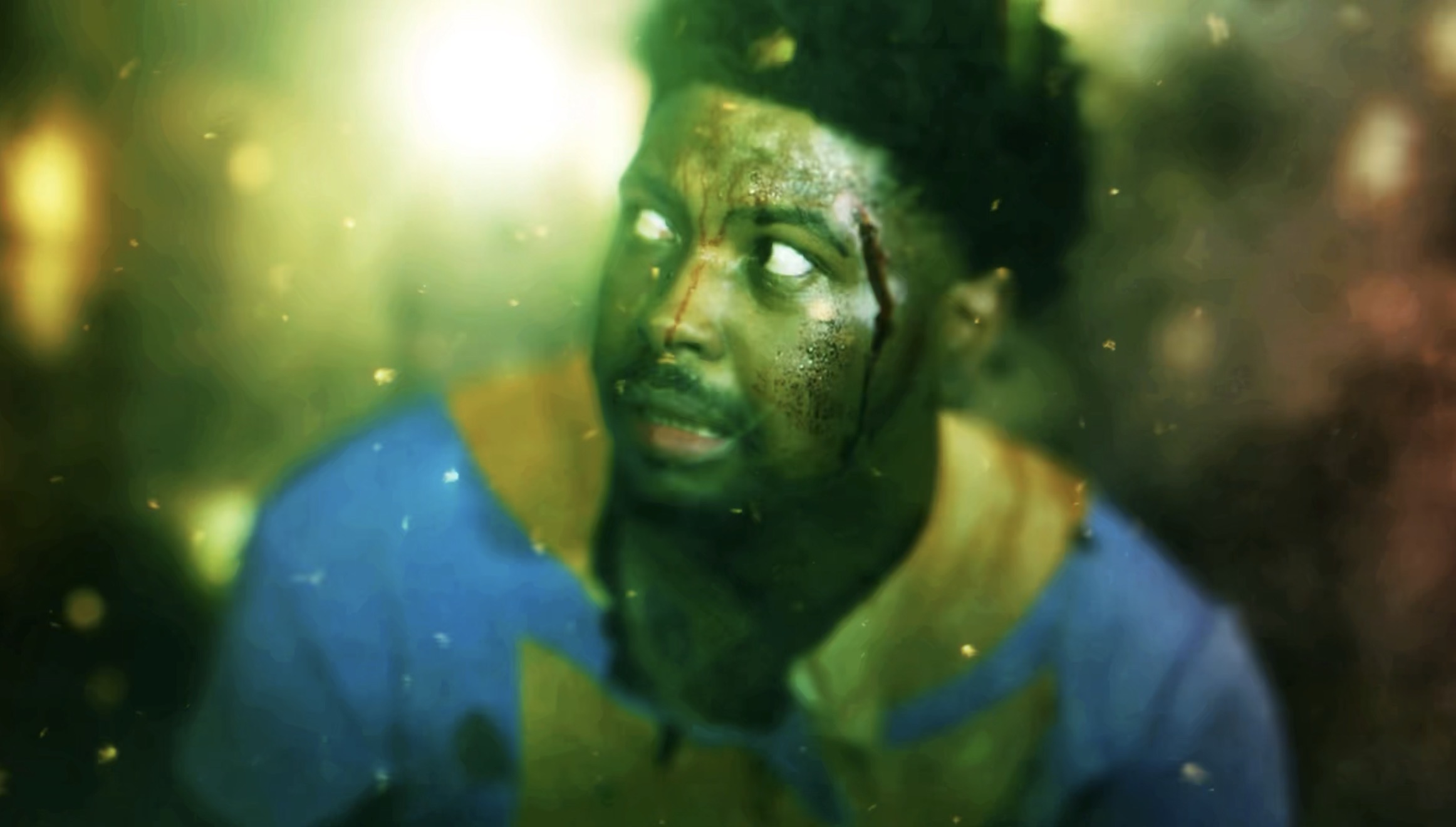 A young man with a distressed expression, looking upward, with a blurred, colorful background.