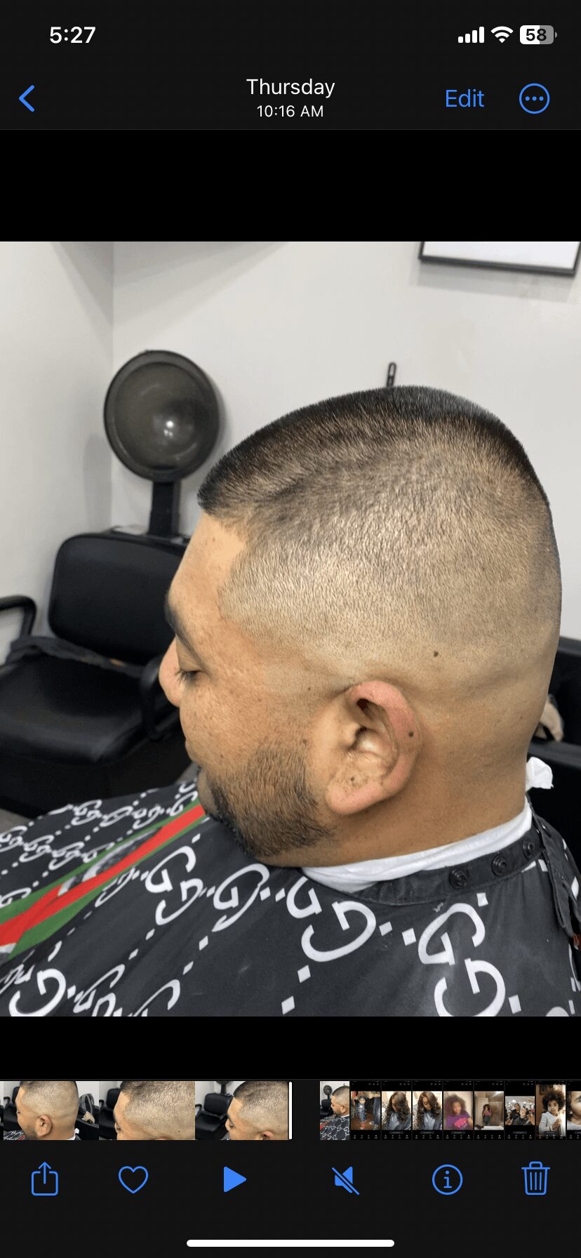 Side view of a person's head with a fresh fade haircut, in a barbershop chair, hair clippers visible.