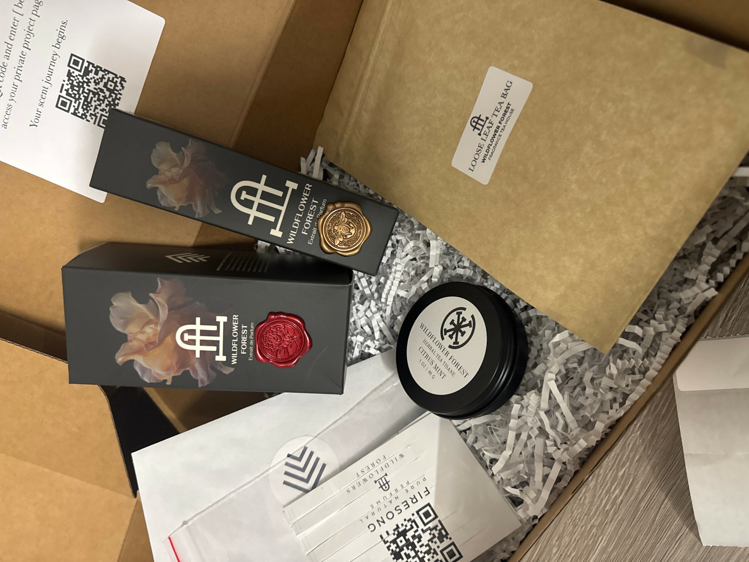 Various packaged products, including a black box with a rabbit illustration, a jar, and a brown box, on a patterned surface.
