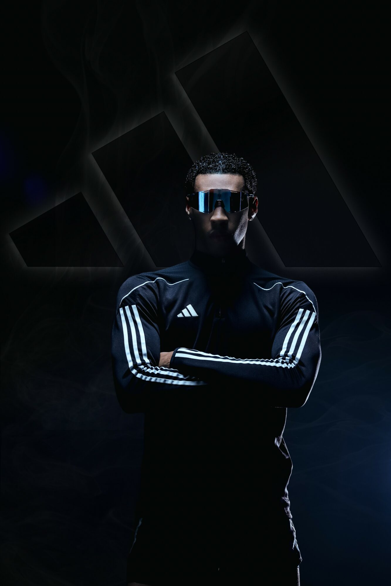 Person wearing sunglasses and sportswear with arms crossed, dark background with geometric shapes, dramatic lighting.