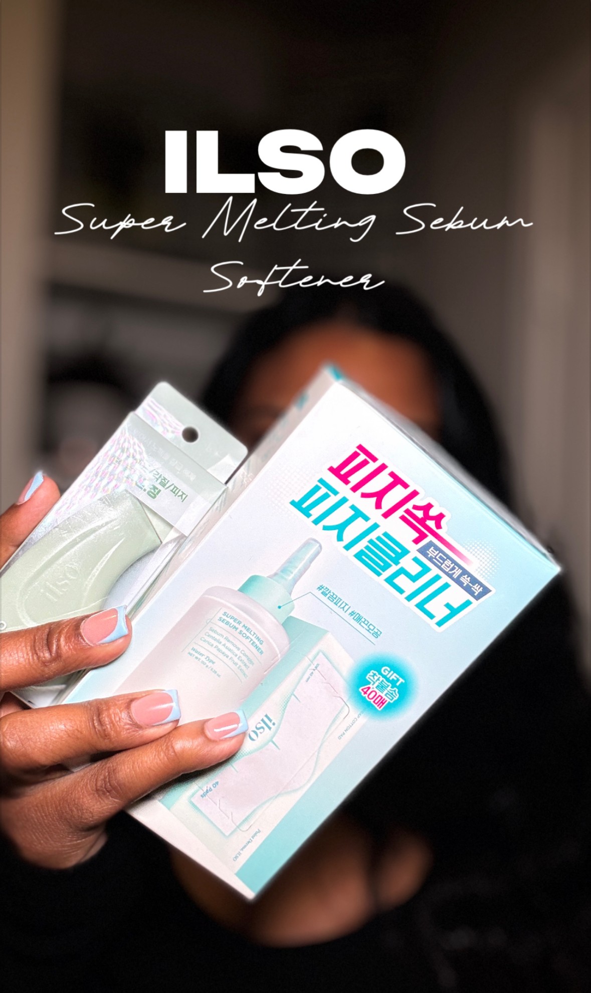Person holding a box of ILSO Super Melting Serum in front of face, background blurred.