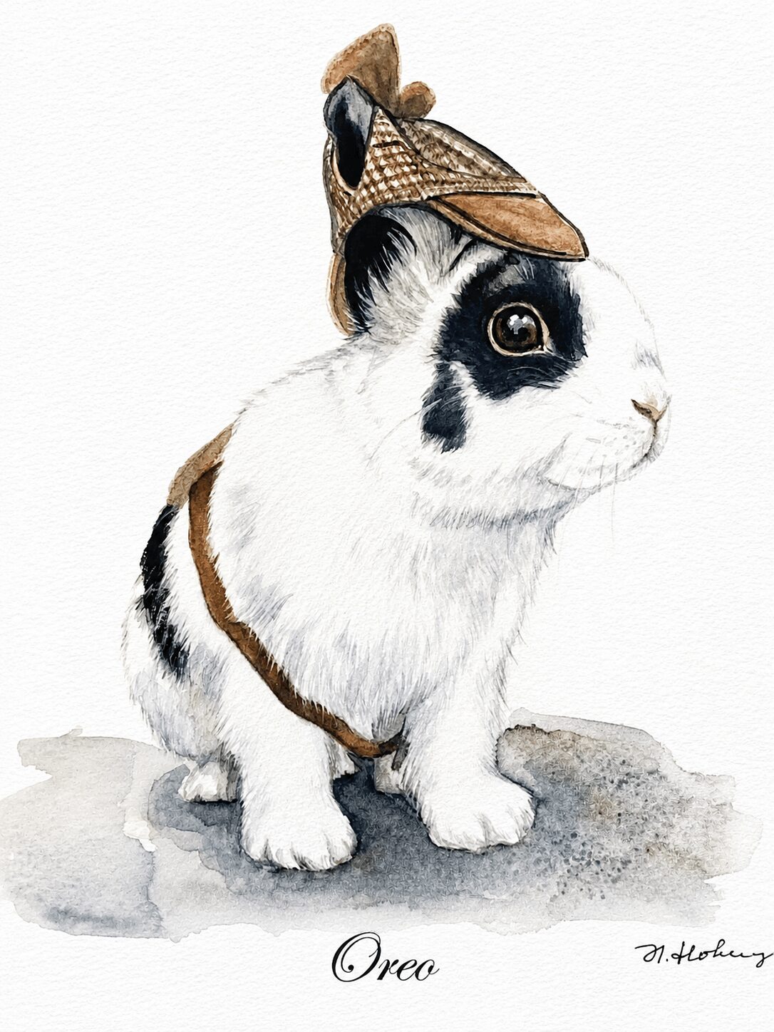 A rabbit wearing a small hat and harness, sitting on a surface, with the name 'Orea' written below.