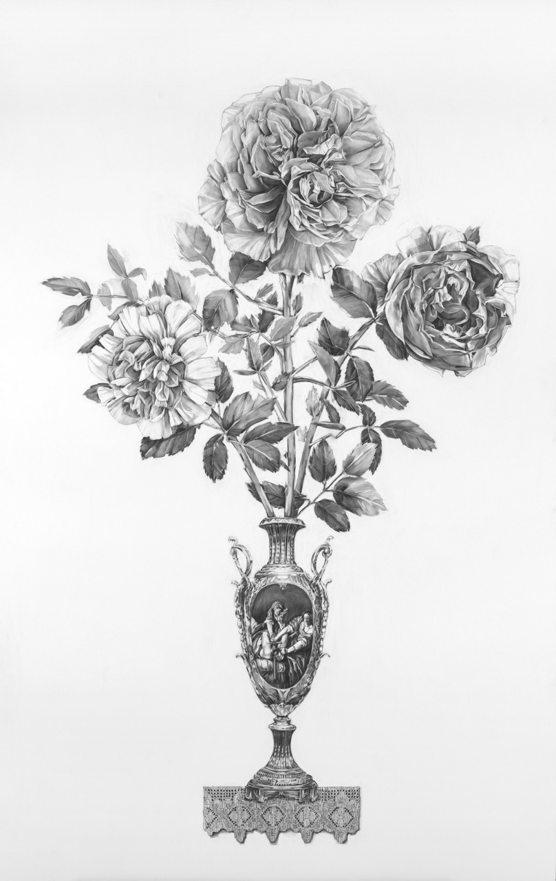Three large roses in a decorative vase with leaves, on a plain background.