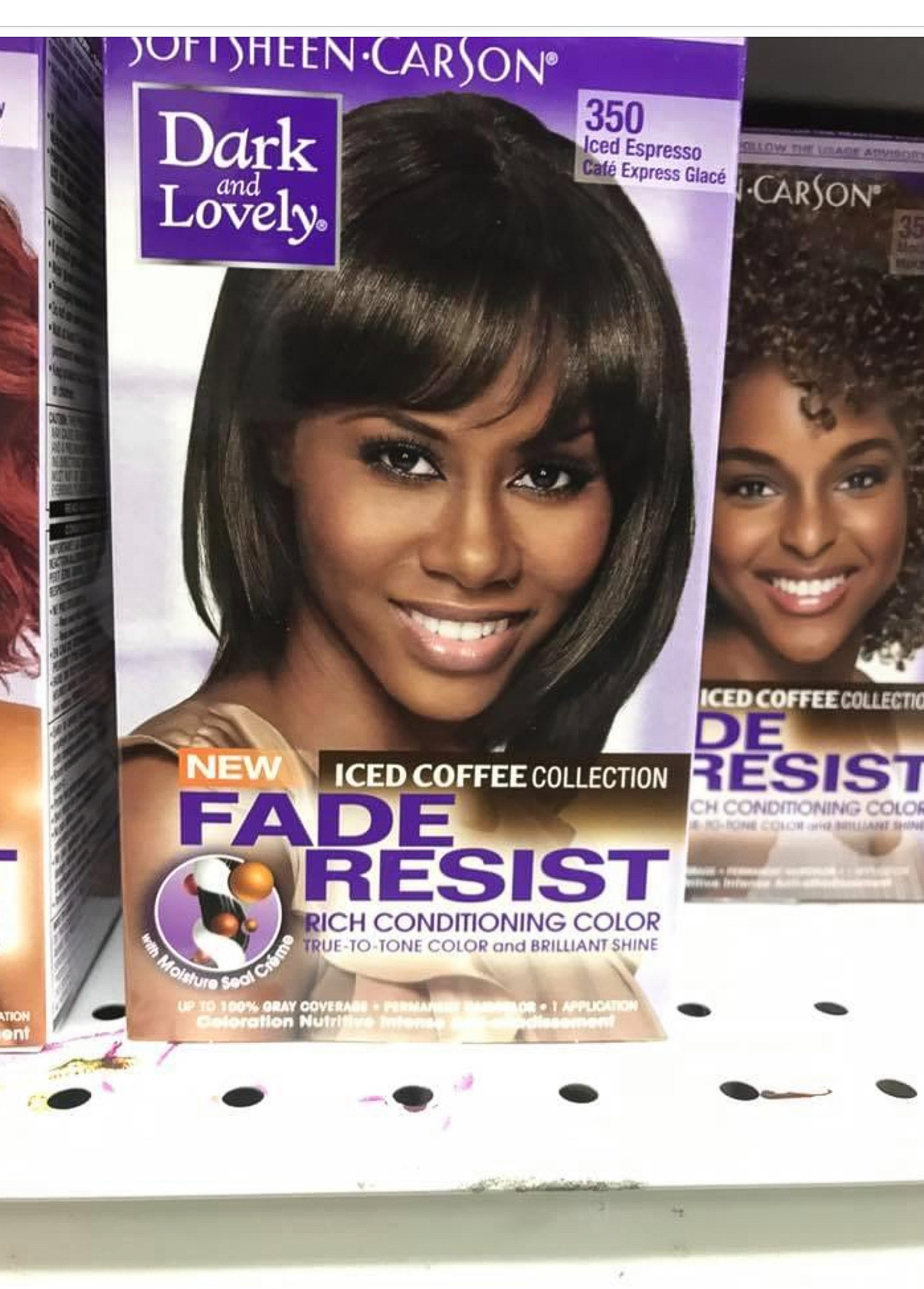 Box of hair dye with a smiling woman with dark, straight hair on the front, purple and white packaging, and text.
