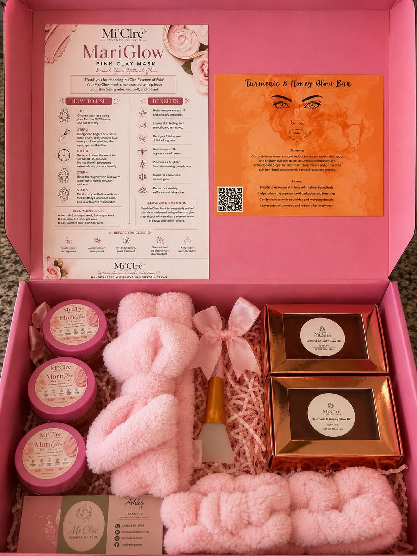 Open pink box containing skincare products, pink headbands, and informational cards inside. Bright pink interior with product packaging visible.