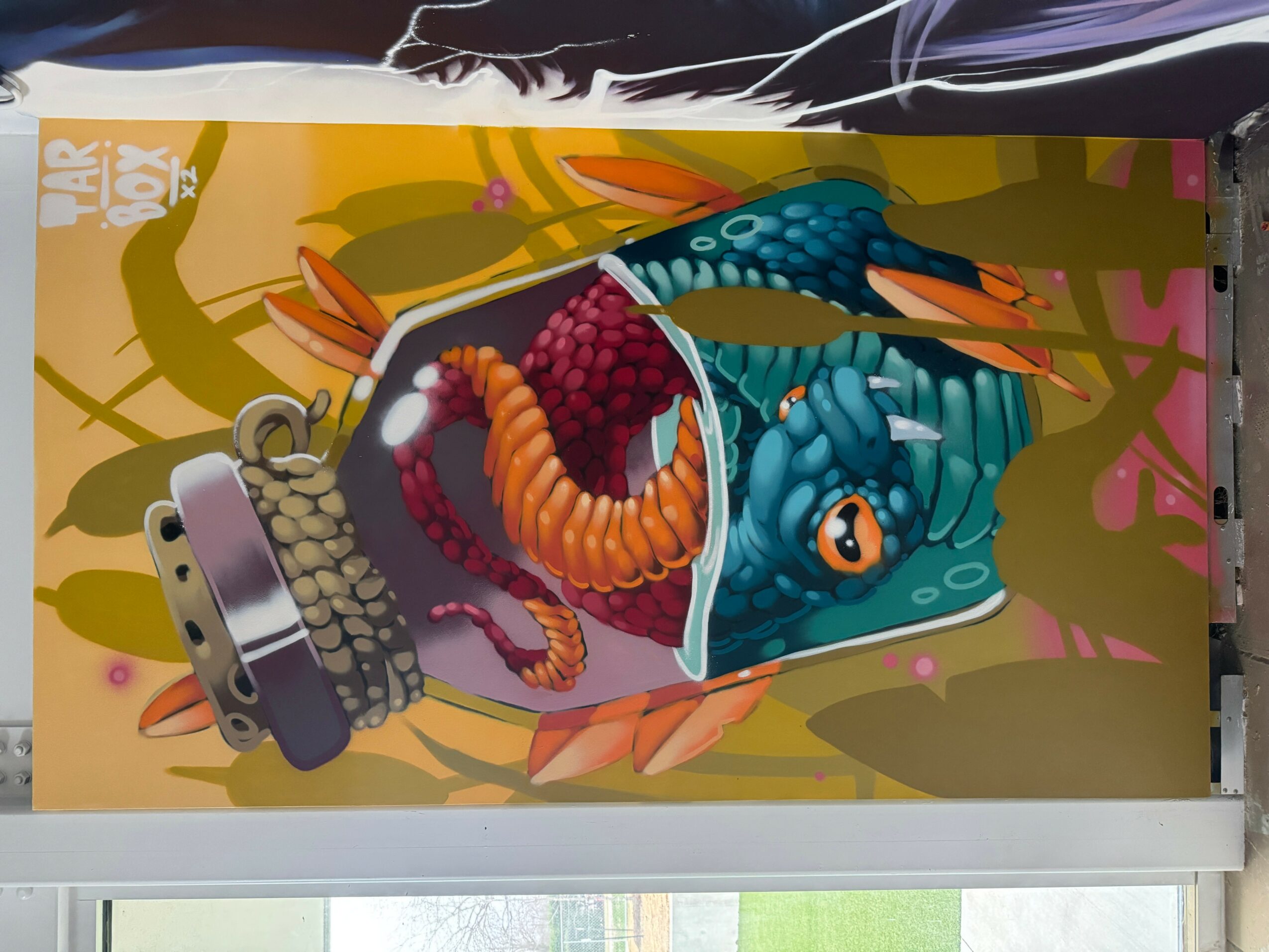 A colorful illustration of a dragon's head emerging from a cup, with a background of trees and branches.
