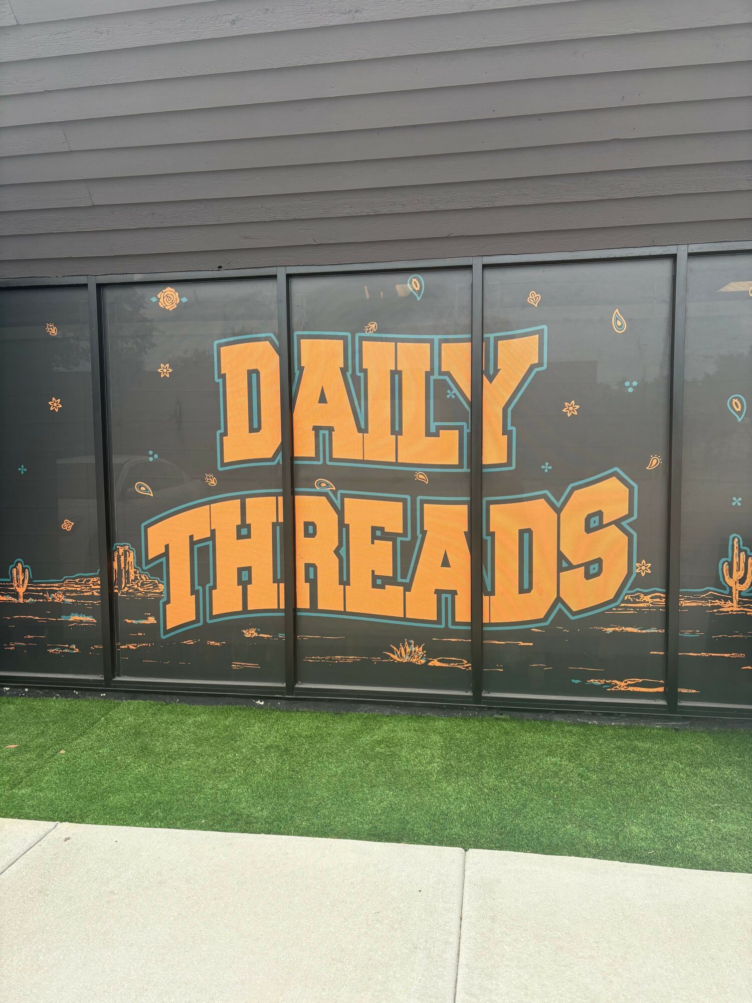 Glass door with orange text reading 'DAILY FIRE SAFETY' and small fire icons, next to a grassy area.