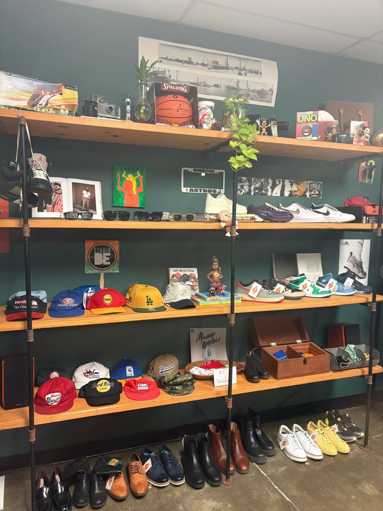 Shelves with shoes, hats, and decorative items, viewed from the side, with a row of shoes on the floor.
