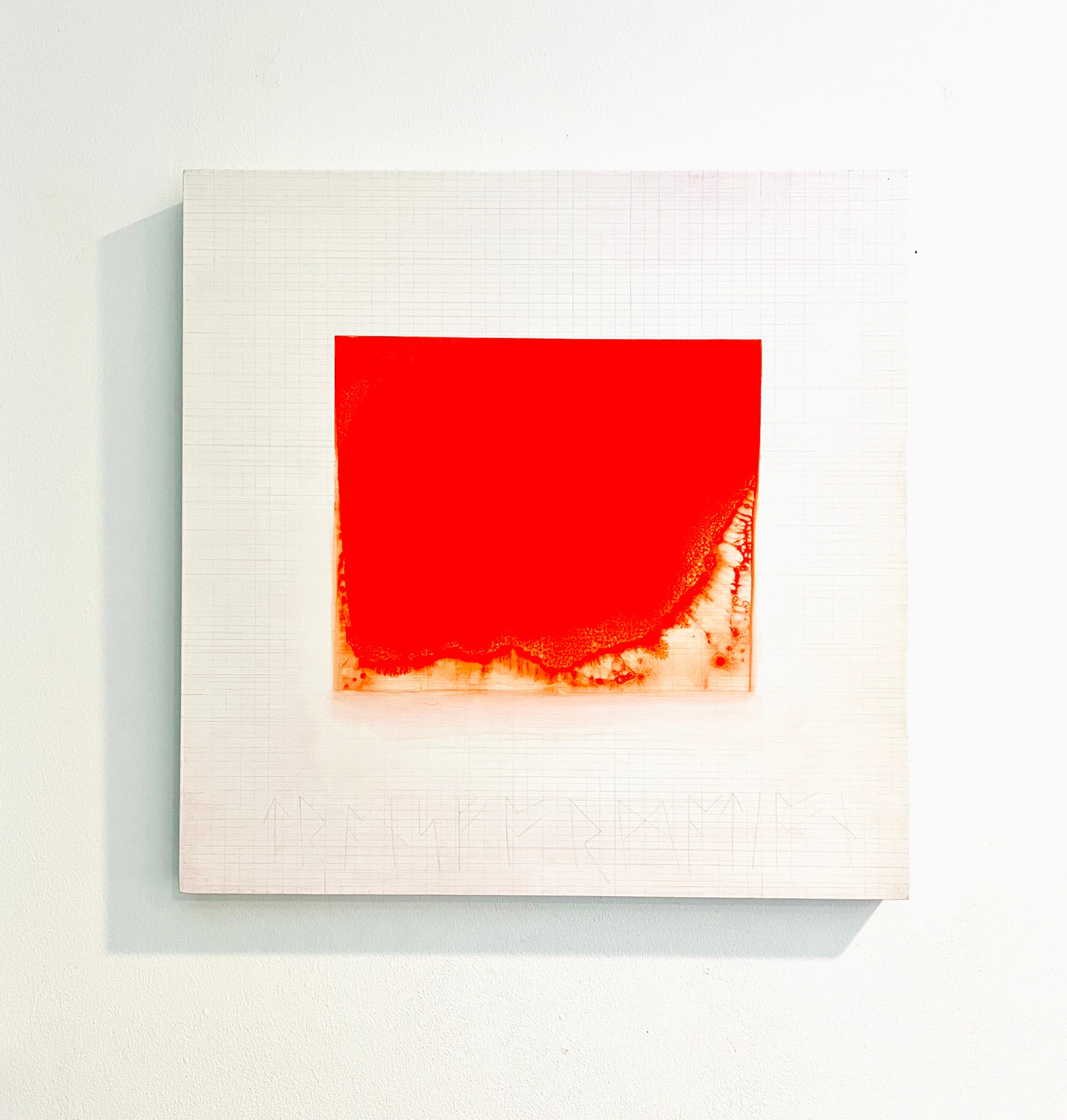 Red square painting on white textured background, shadow cast to the left, minimalistic art display.