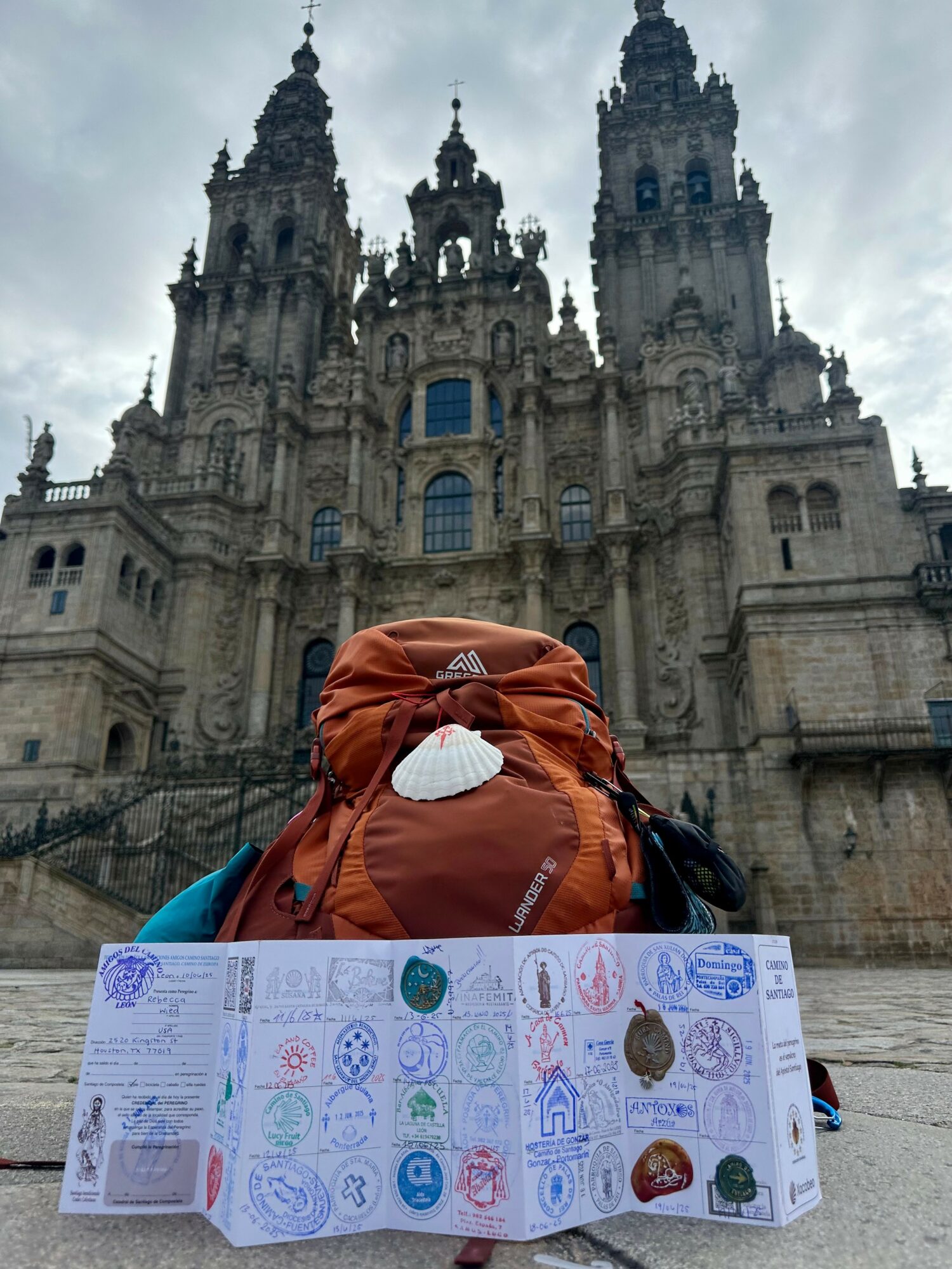 Person with a backpack and travel document in front of a historic cathedral with tall towers and ornate architecture