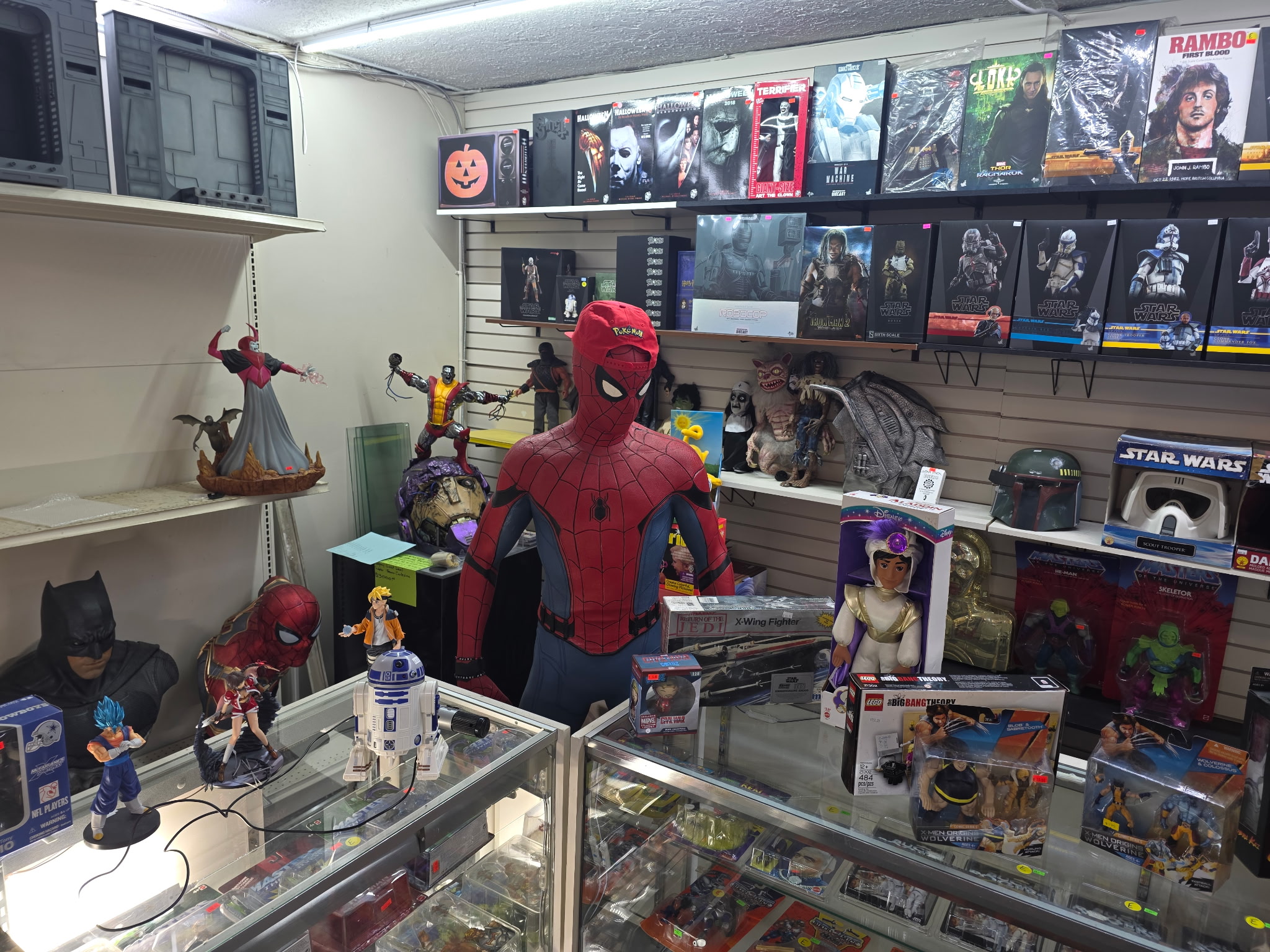 Spider-Man figure in a toy store surrounded by various action figures and collectibles on shelves and display cases.