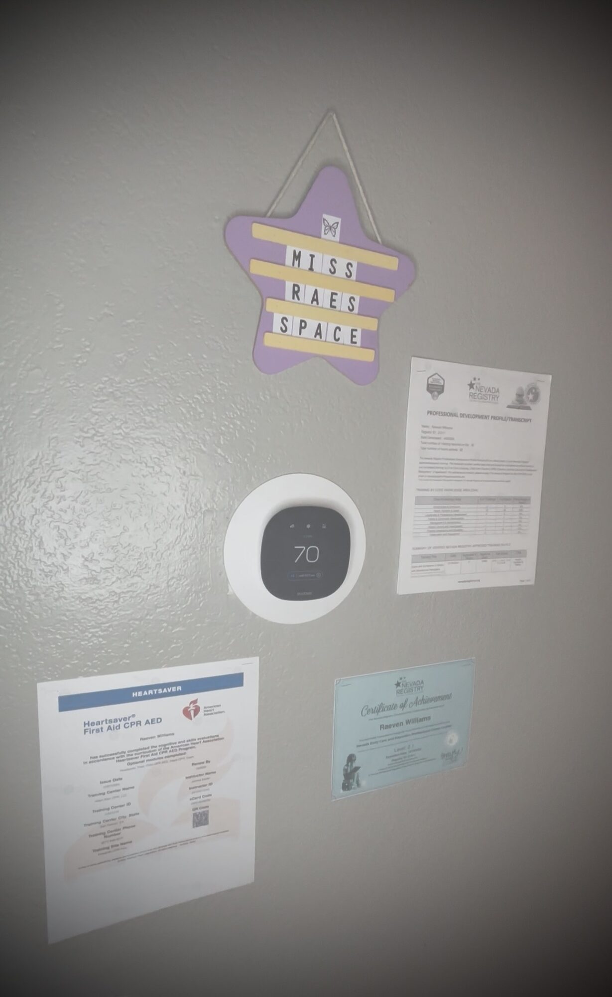 Wall with star-shaped decoration, thermostat, and various papers attached, all upright and visible.