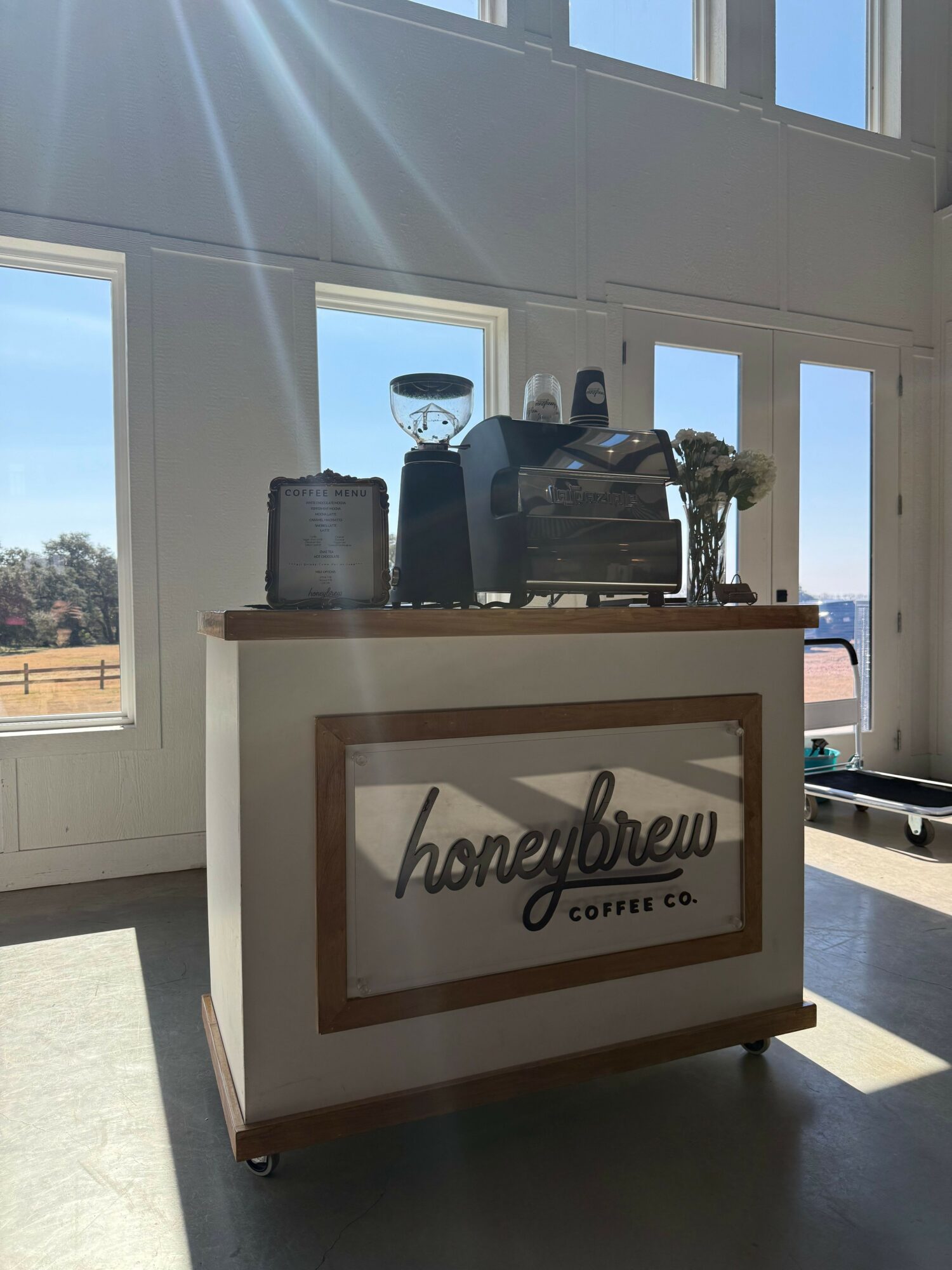A reception desk with a sign reading 'Welcome' and 'Office' in a bright room with large windows.