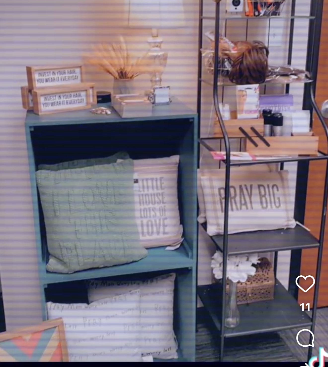 Books, decorative items, and pillows on shelves in a cozy room corner.