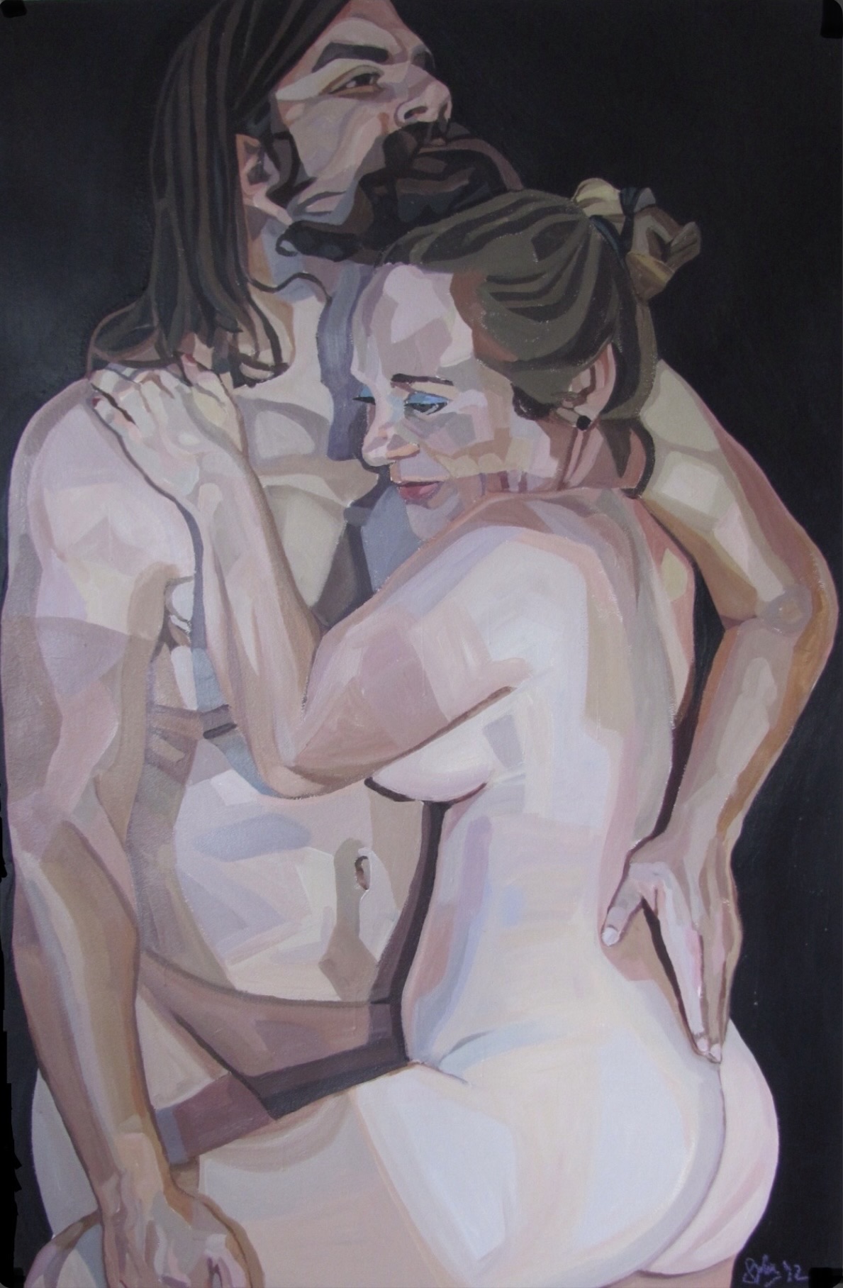 Two nude women embrace, smiling and holding each other closely, with dark background and soft lighting.