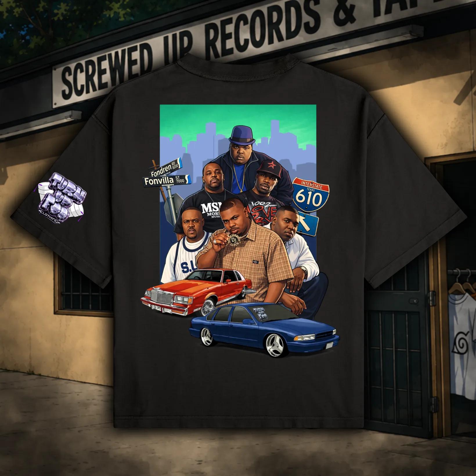 Black T-shirt with a colorful graphic of five men, two cars, and a city skyline background.
