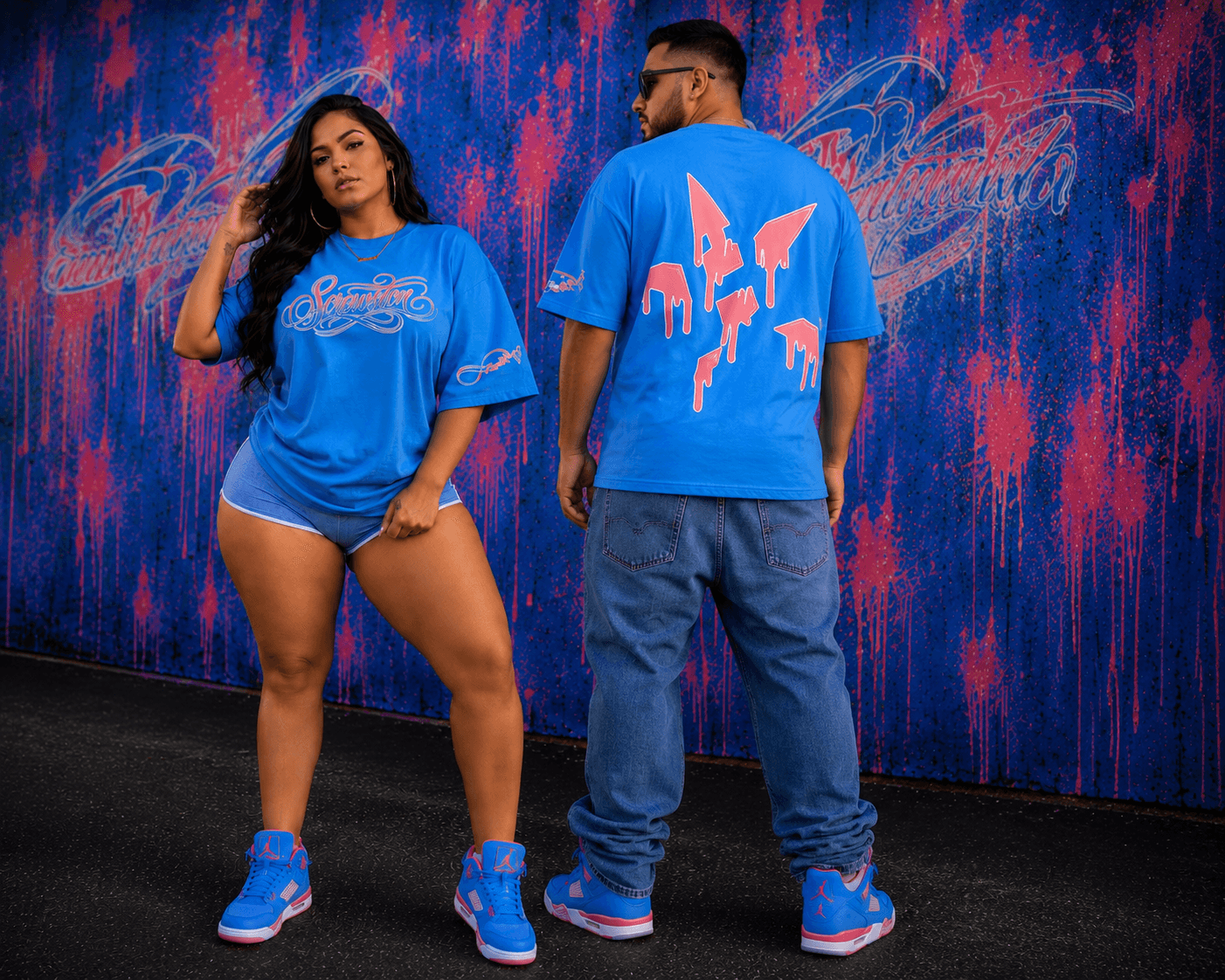 Two people stand in front of a colorful abstract background, wearing blue clothing and sneakers, facing away and looking at each other.