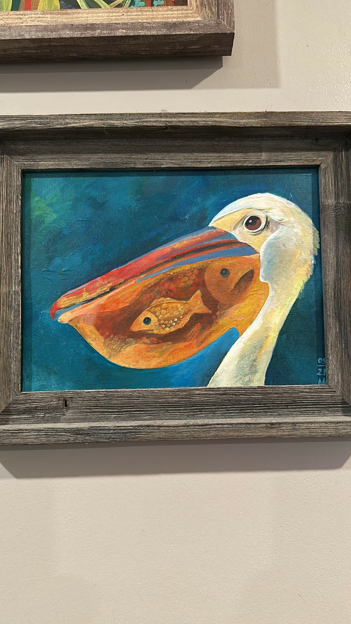 Painting of a bird with a fish inside its beak, framed and hung on a wall.