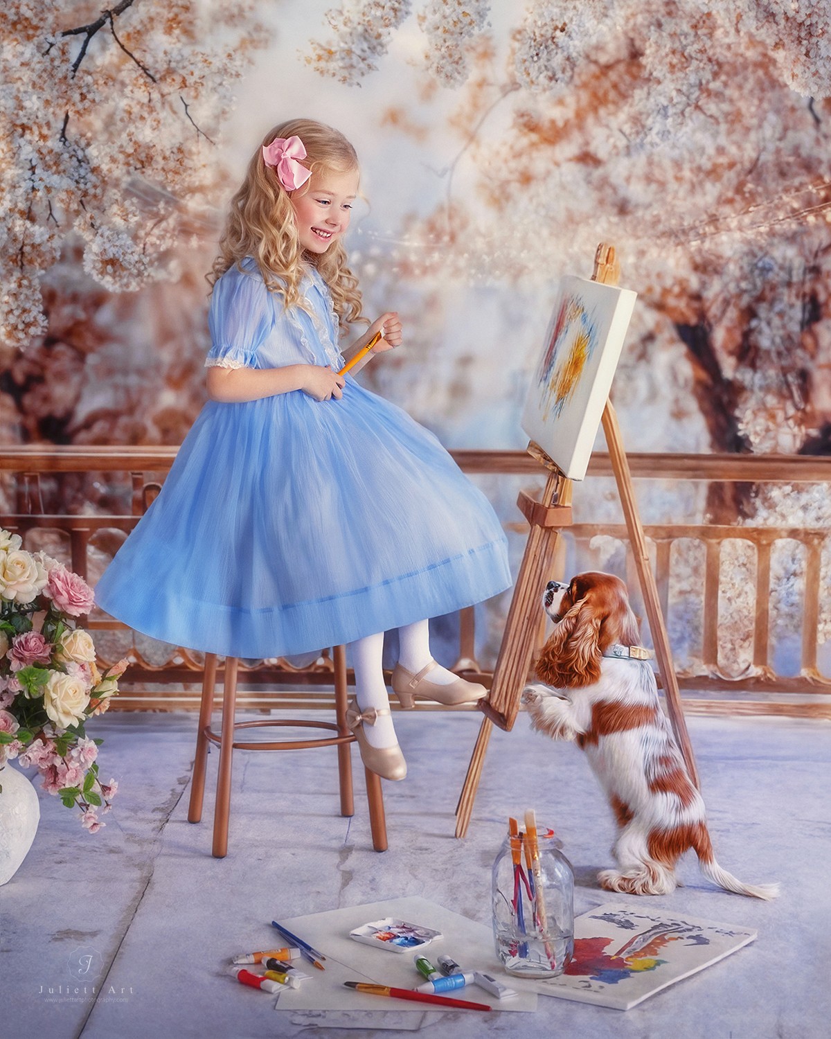 Young girl in a blue dress sitting on a chair, painting on an easel, with a dog nearby, outdoors with trees.