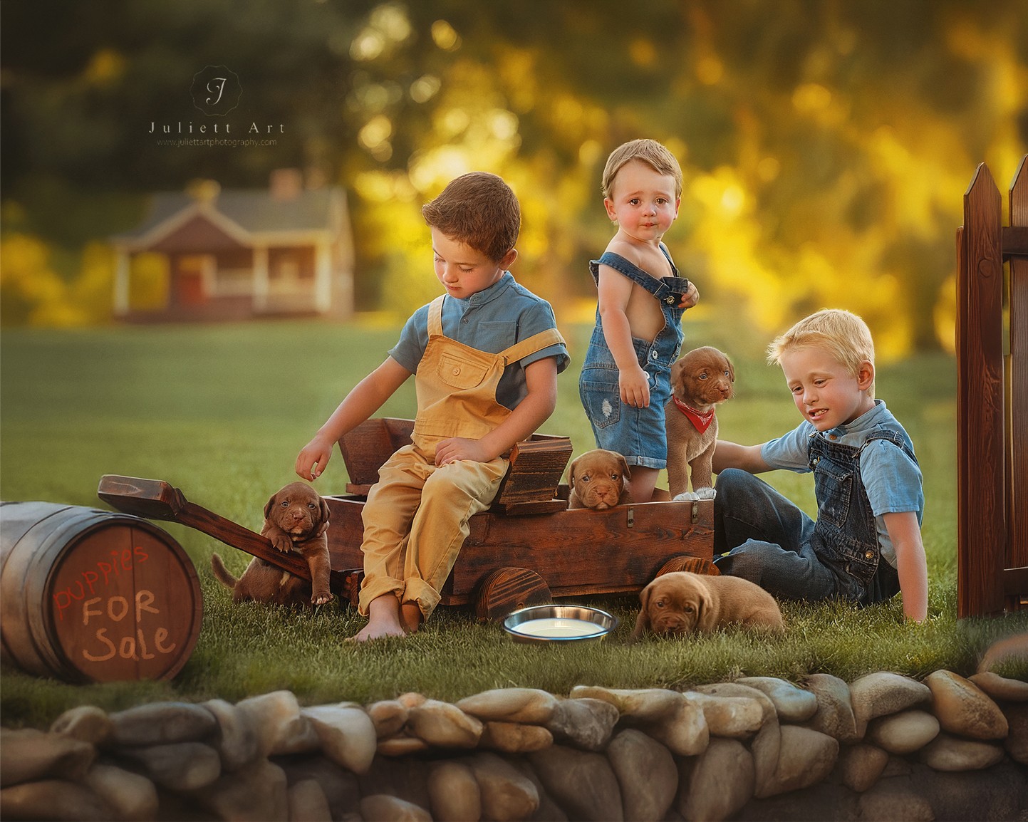 Three children and two dogs sit on a wooden cart outdoors, with a house and trees in the background, during sunset.