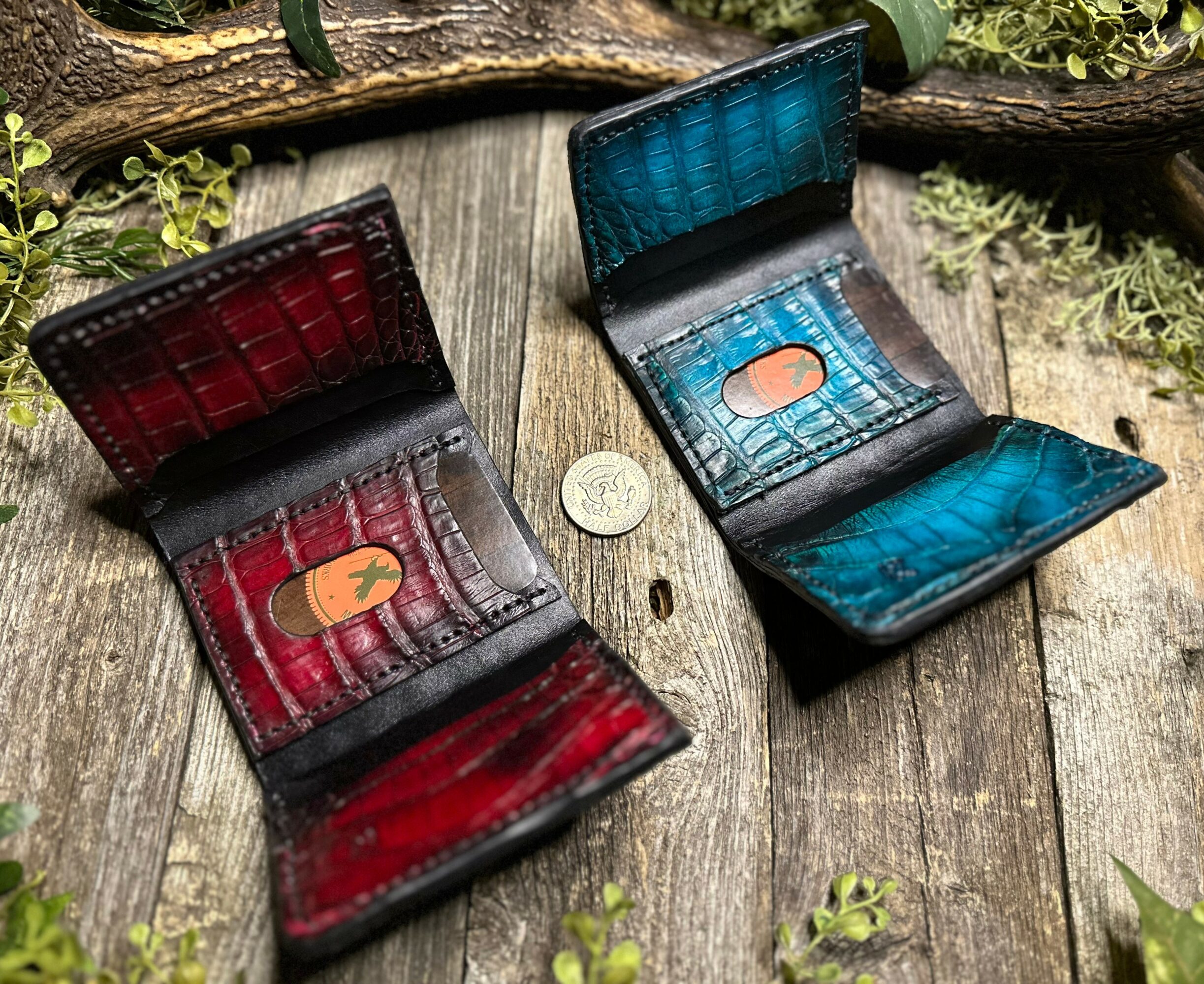 Two open wallets, one red and one blue, placed on a wooden surface with a coin between them.